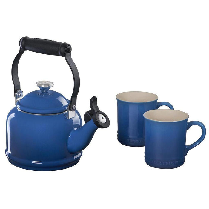 Blue tea kettle with two blue colored mugs displayed on a white background