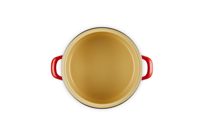 Dark cream inside of the enamel on steel traditional petite stockpot with handles on a white background