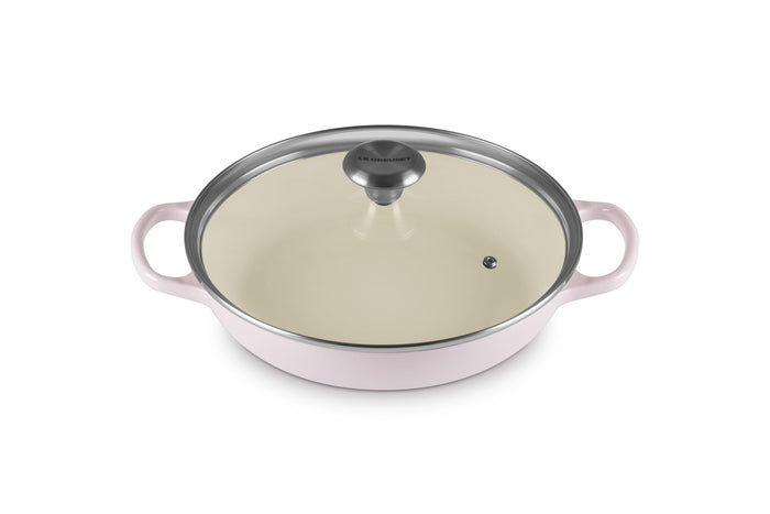 A shallot Le Creuset Enameled Cast Iron Signature Round Braiser with a glass lid on a white background