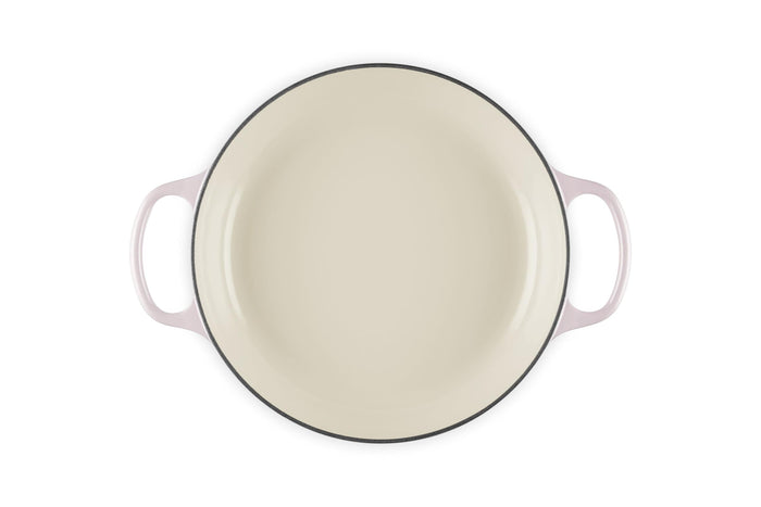 Cream inside of a 2.25 qt enameled cast iron signature round braiser with handles on a white background