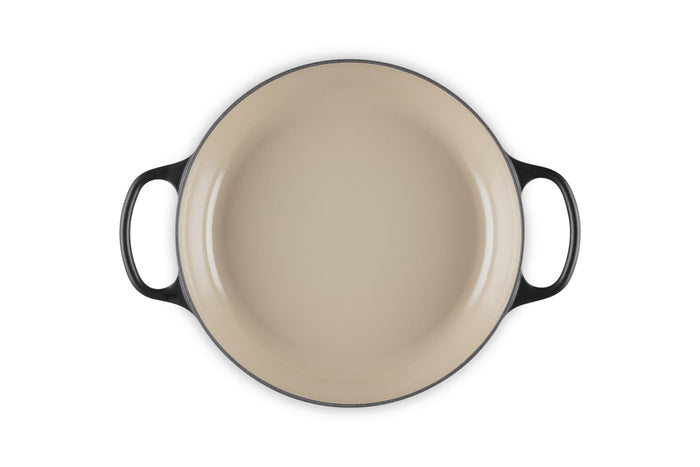 Cream inside of a 2.25 qt enameled cast iron signature round braiser with handles on a white background