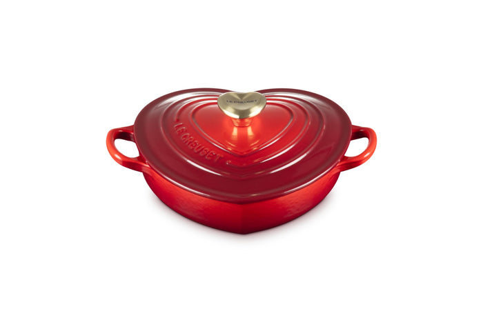 Cerise heart shaped 1.25 qt cocotte with handles and a light gold heart knob displayed on a white background