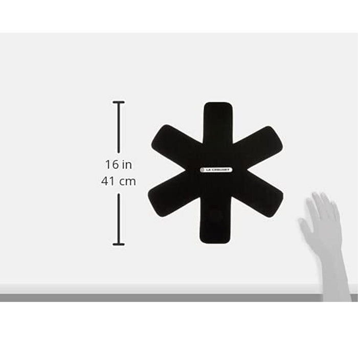 Top view of black Le Creuset Felt Pan Protector with dimensions next to a greyed out hand displayed on a white background