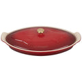 Red ceramic dish with fish design and 'Le Creuset' branding on a white background
