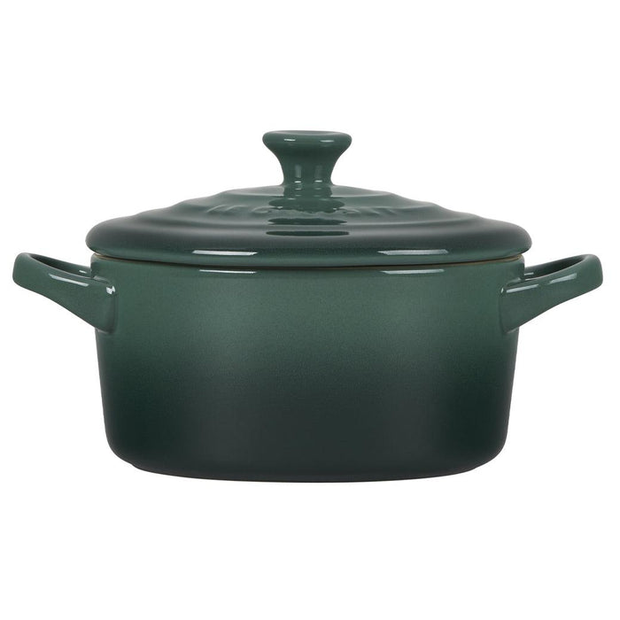 Side view of green Le Creuset Mini Round Cocotte 14 oz with lid displayed on a white background