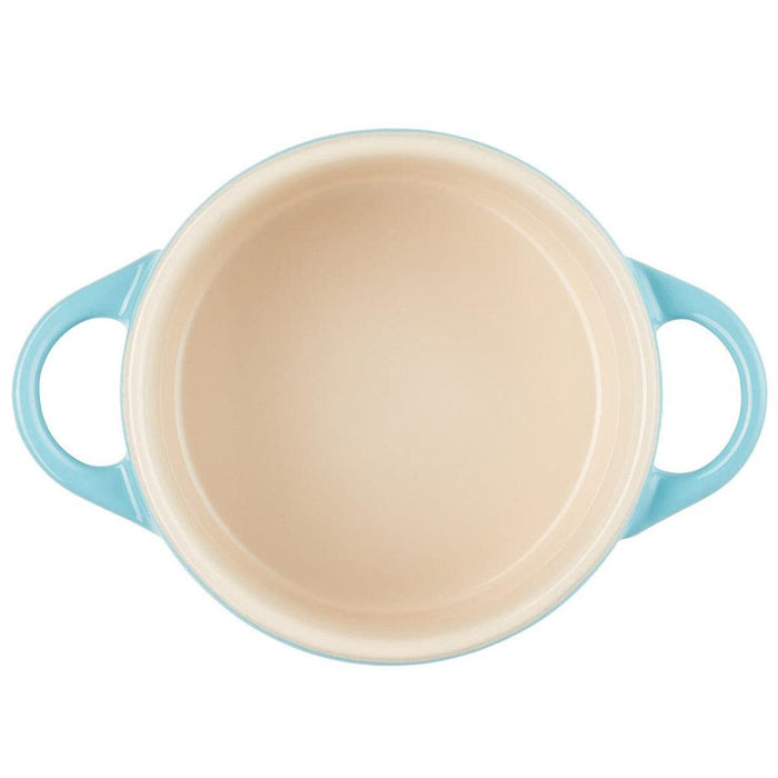 Top view of Caribbean Le Creuset Mini Round Cocotte 8 oz with a cream interior displayed on a white background