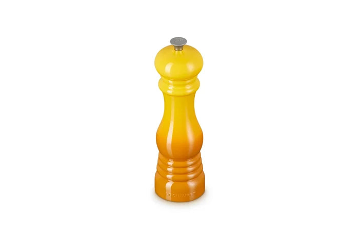 A yellow-to-orange gradient pepper mill with a silver metal top, centered on a plain white background.