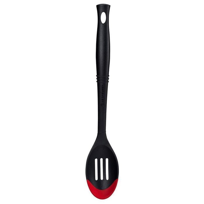 Cerise Le Creuset Revolution Bi-Material Slotted Spoon displayed vertically on a white background