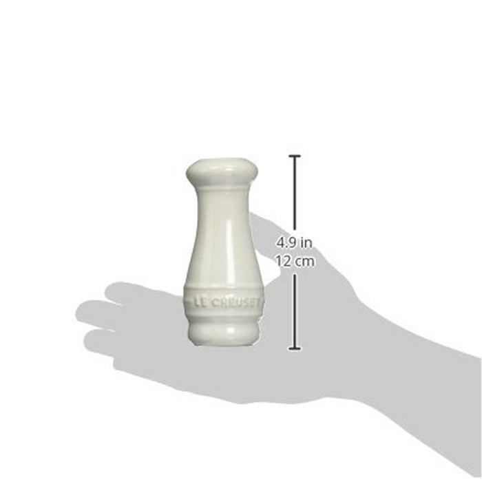 Someone holding a white Le Creuset Salt and Pepper Shaker with dimensions displayed on a white background