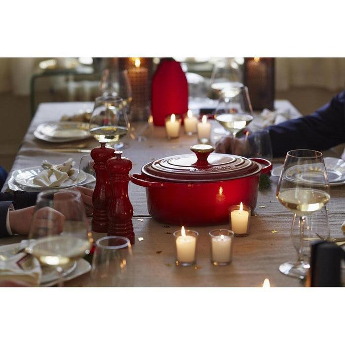 Le Creuset Salt Mill next to Le Creuset cookware on a dinner table with romantic setting on the table