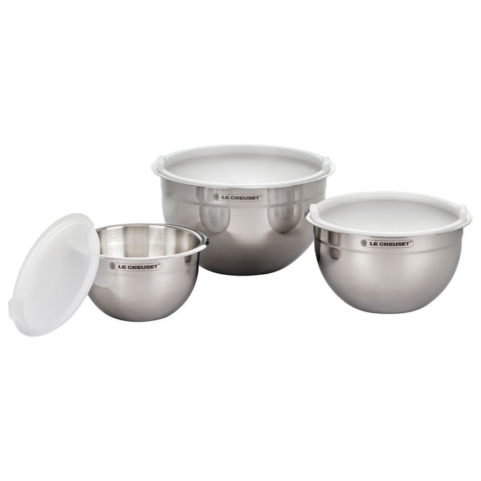 Set of three stainless steel mixing bowls with lids on a white background, featuring the Le Creuset brand.