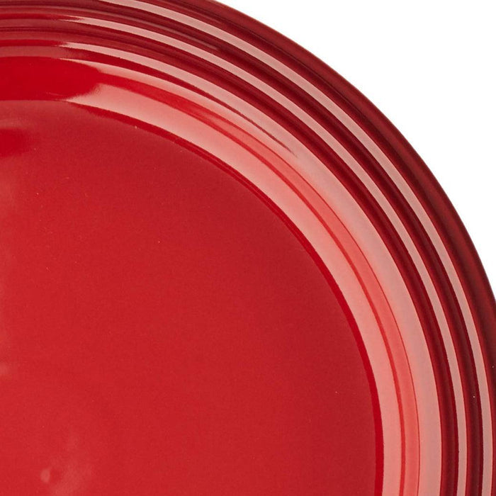 Close up of cerise Le Creuset  10.5″ Dinner Plate displayed on a white background