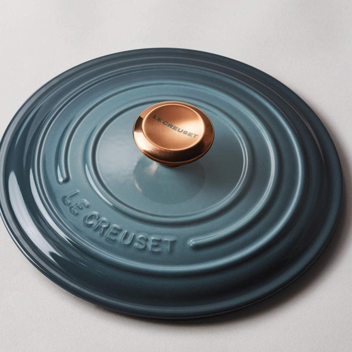 Le Creuset Signature Copper Knob placed on a Le Creuset lid displayed on a white background
