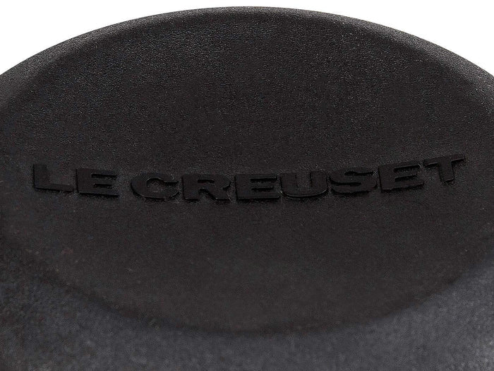 Close up of logo on Le Creuset Signature Phenolic Knob displayed on a white background