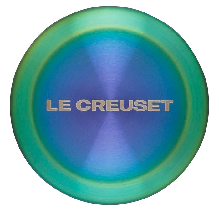 Le Creuset logo on a steel iridescent knob on a white background