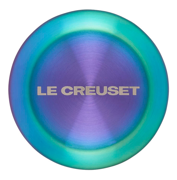 Le Creuset logo on a steel iridescent knob on a white background