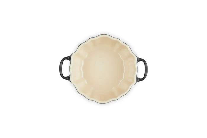 An oval baking dish with a cream-colored interior and dark gray handles, shown from a top-down view on a white background.