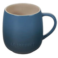 Blue mug with beige interior on a white background, featuring Le Creuset branding.