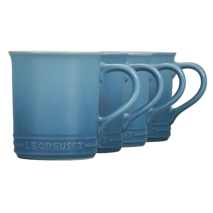 Caribbean Le Creuset Stoneware Set of 4 (14 oz.) Mugs displayed diagonally in a row on a white background