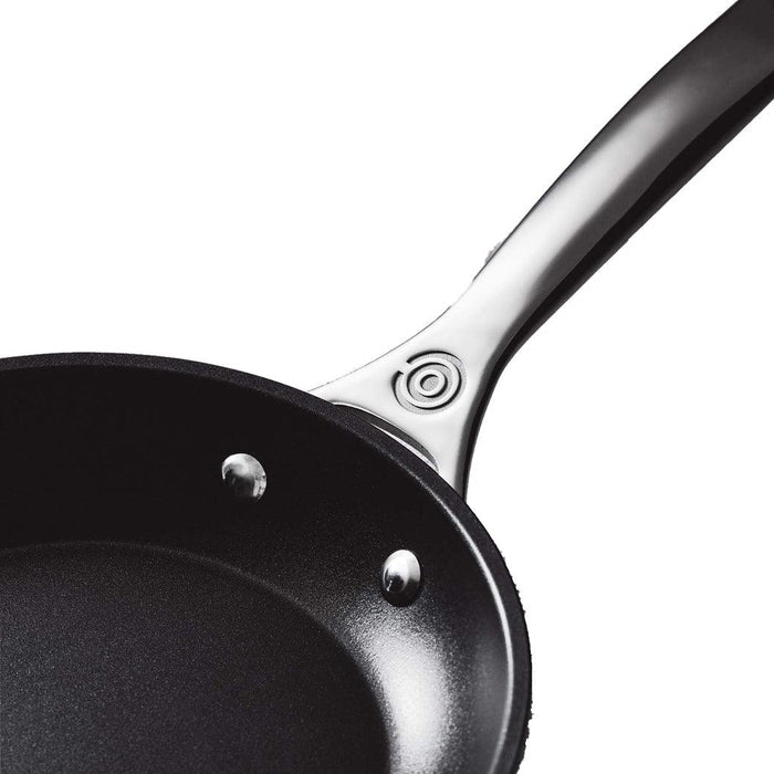 Close up of hilt of handle of Le Creuset Toughened Nonstick PRO fry pan dispalyed on a white background