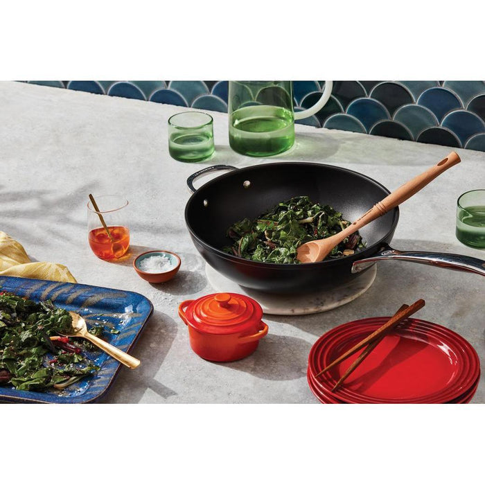 Le Creuset Toughened Nonstick Stir Fry Pan, 12″ with cooked vegetables next to glasses of water