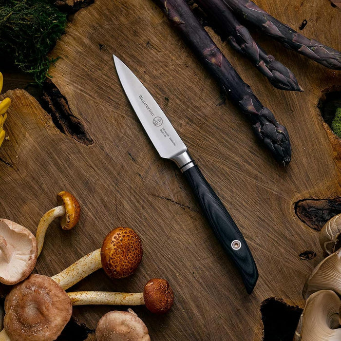 Knife on a wooden cutting board with mushrooms and asparagus