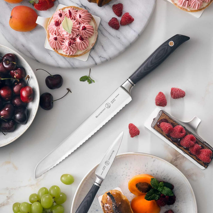 Fruits, pastries, bread knife, and paring knife on a marble surface