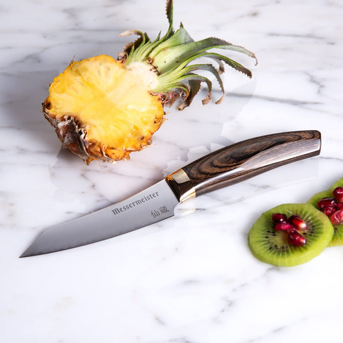 3.75 inch paring knife next to sliced up kiwi and pineapples displayed on a marble surface