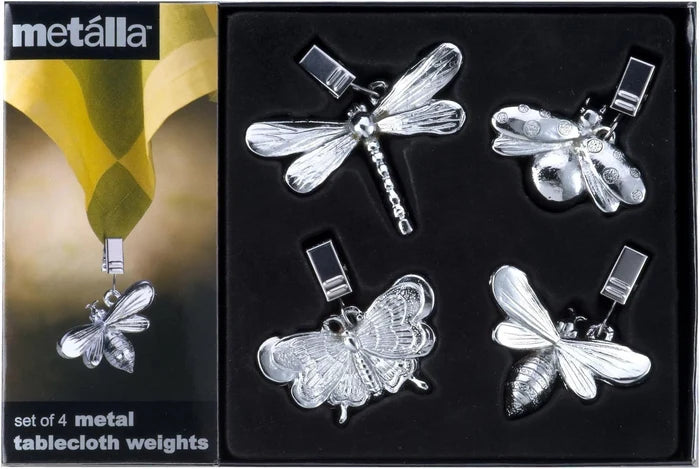A set of four metal tablecloth weights in dragonfly, butterfly, bee, and ladybug shapes, displayed in a black presentation box with the Mettalla brand logo.