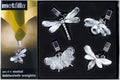 A set of four metal tablecloth weights in dragonfly, butterfly, bee, and ladybug shapes, displayed in a black presentation box with the Mettalla brand logo.