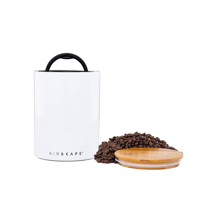 White air tight container with black handle and lid, with coffee beans on a white background.