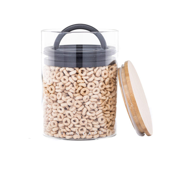 Airscape glass jar with cereal inside and airtight lid as well as a bamboo lid on the side on a white background