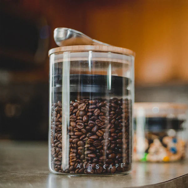 Life image of airscape glass container with bamboo lid in a kitchen setting with a scoop on top