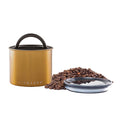 Brass-colored coffee canister with lid, coffee beans, and a clear container on a white background