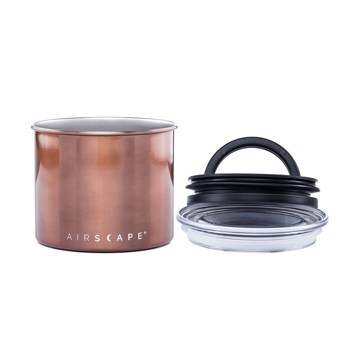 Copper-colored coffee canister with lid on the side on a white background