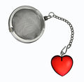A stainless steel ball tea infuser with a short chain and a red heart-shaped charm, shown on a plain white background.