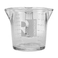 Clear glass measuring cup with 'Revolution' logo on a white background