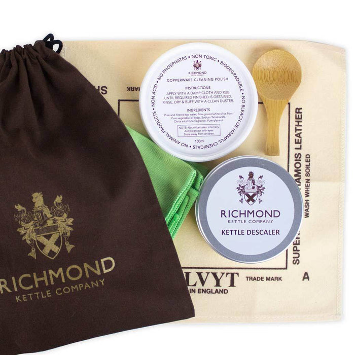 Richmond Kettle Care Kit contents displayed which include a cleaning brush, wooden scoop, a container labeled 'Kettle Descaler', and a polishing cloth, all arranged on a table with the brand name 'Richmond' visible.