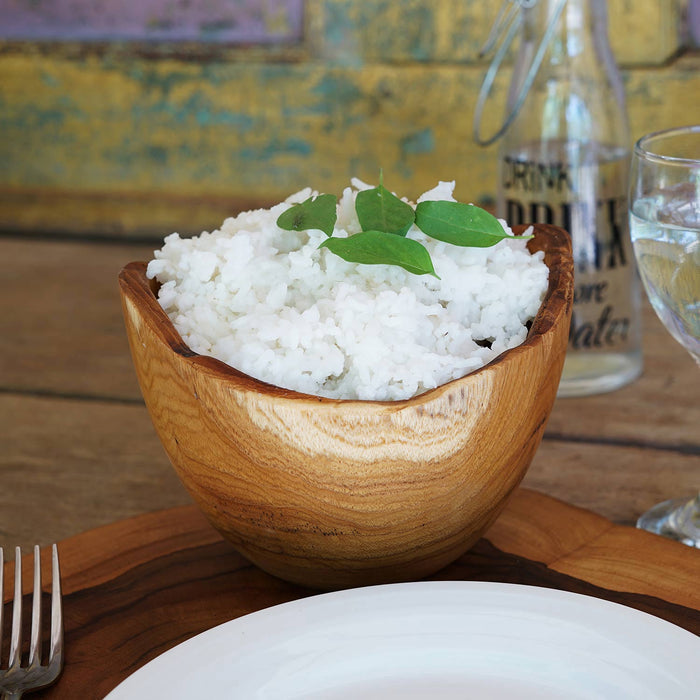Rico & Plato adagio teak bowl with rice inside placed on a wooden table