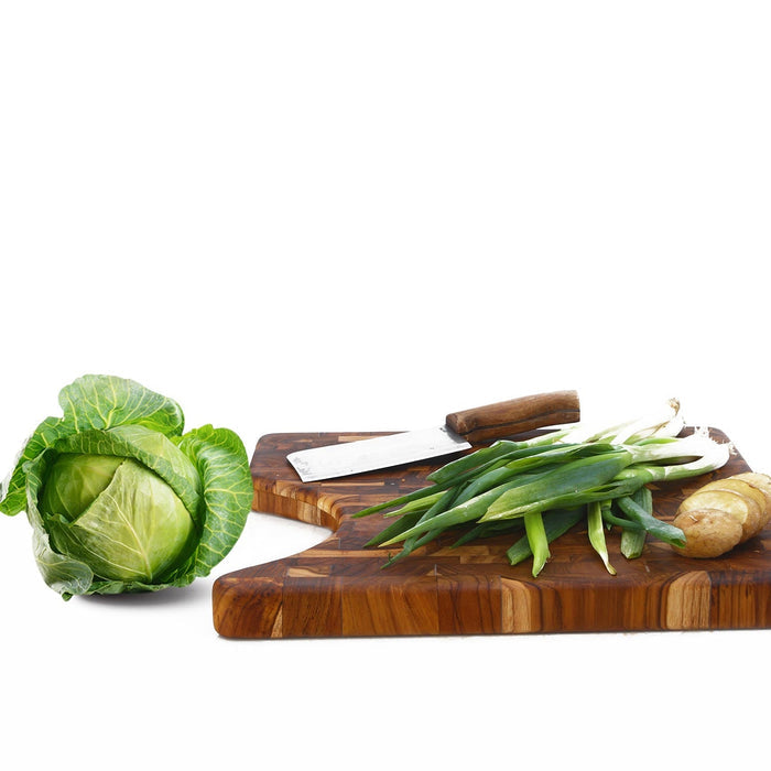 End grain teak cutting board with lettuce, potatoes, green onions, and cleaver displayed on a white background