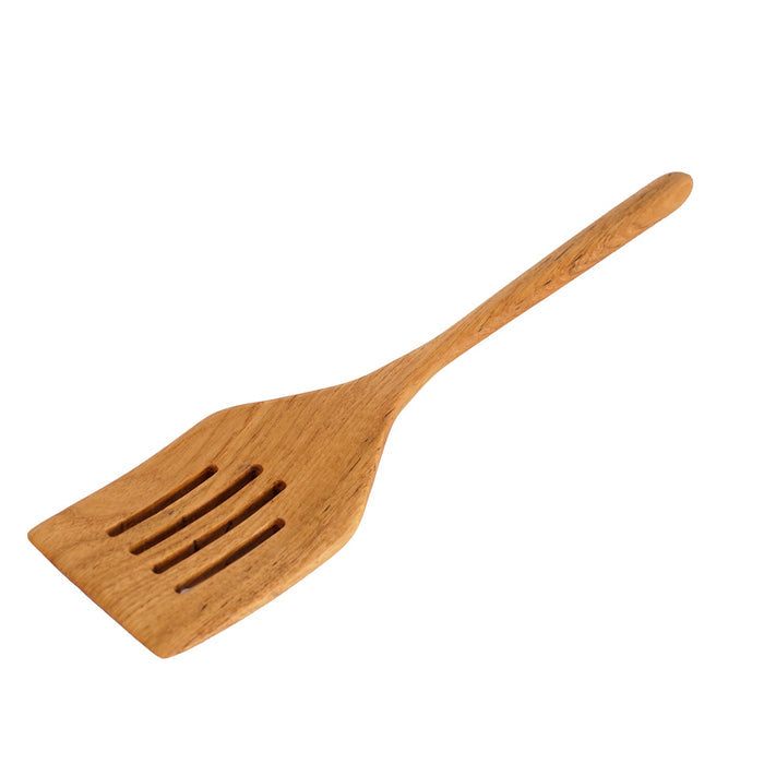 Diagonal view of a teak spatula with drainage slots on a white background