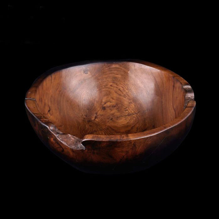 Teak bowl with black burned exterior finish displayed on a black background
