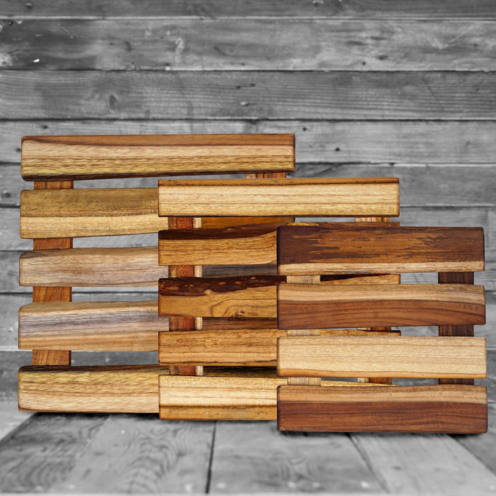 Set of 3 different sized teak trivet placed on a wooden surface
