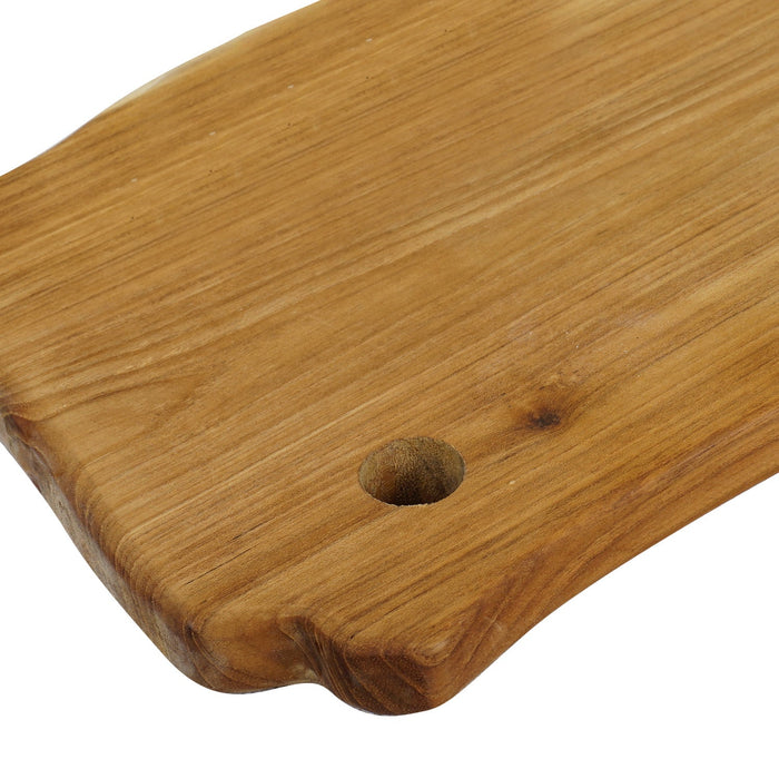 Close up of hole handle of teak cutting board displayed on a white background