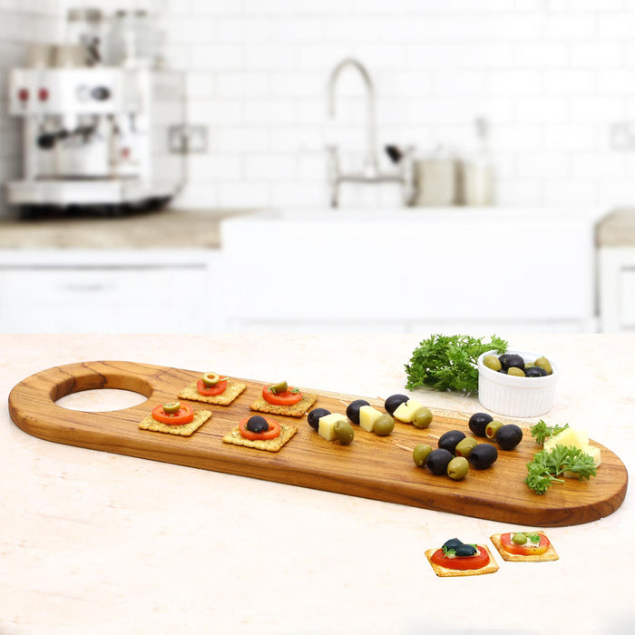 Rico & Plato teak serving board with charcuterie material displayed in a kitchen setting