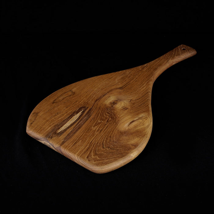 Rico & Plato caraway teak cutting board serving platter displayed on a black background