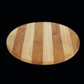 Circular teak cutting board/serving platter with 2 tones of wood displayed on a black background