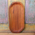 Large teak plate displayed vertically on a colorful, wooden background