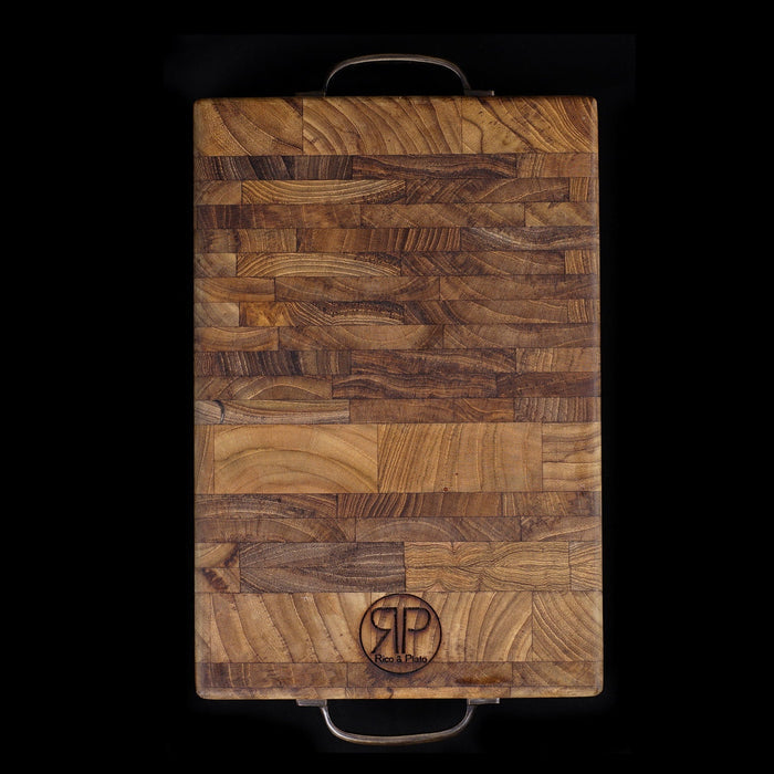 Top view of end grain teak cutting board with handles displayed on a black background