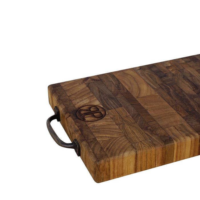 Close up of end grain teak cutting board with handles displayed on a white background
